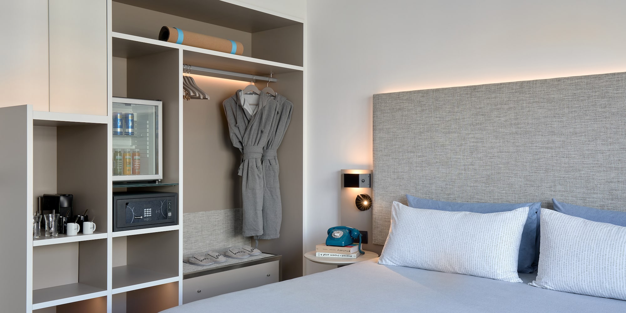 a bed with a white headboard and a shelf with a towel on it