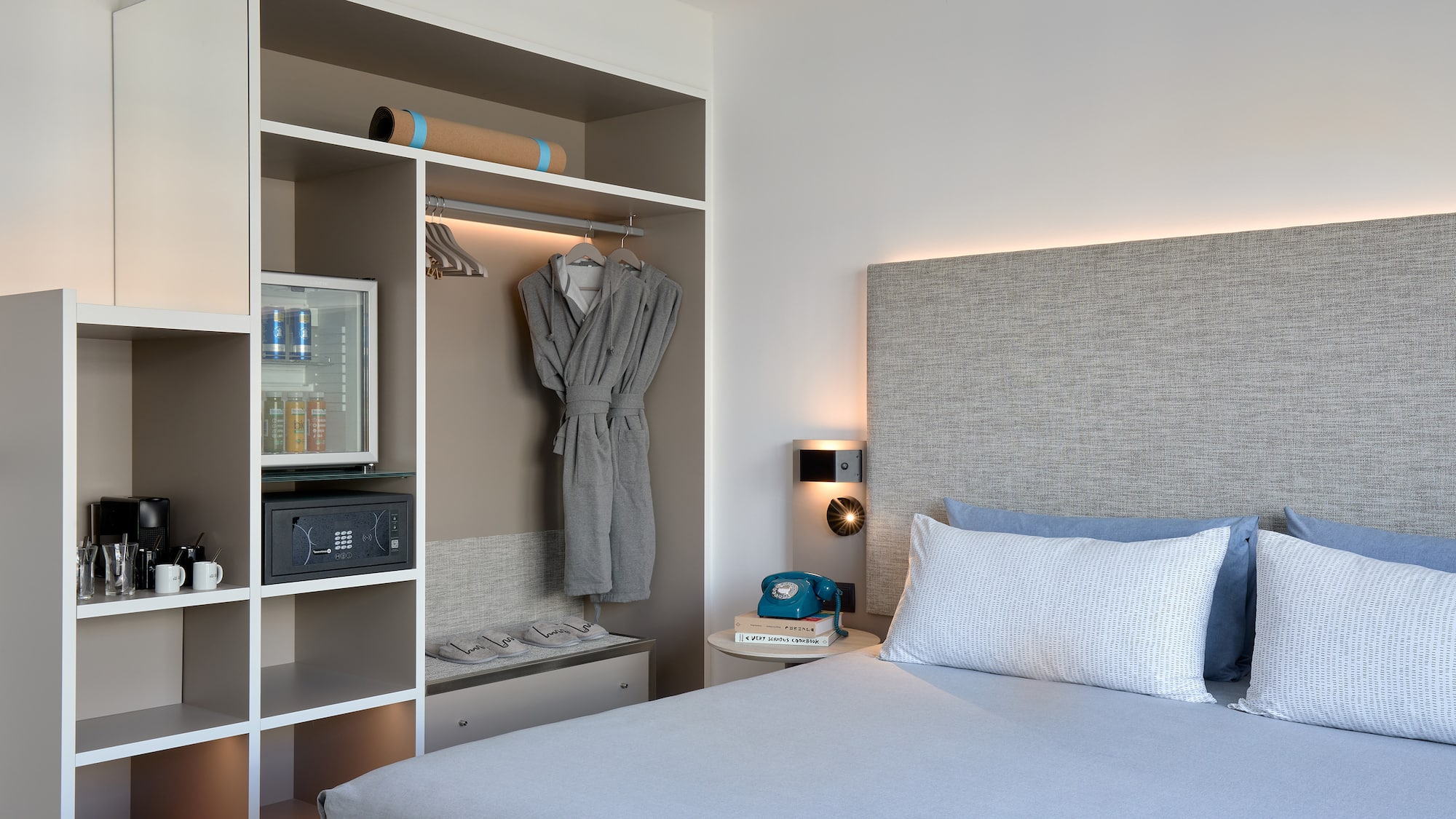 a bed with a white headboard and a shelf with a towel on it