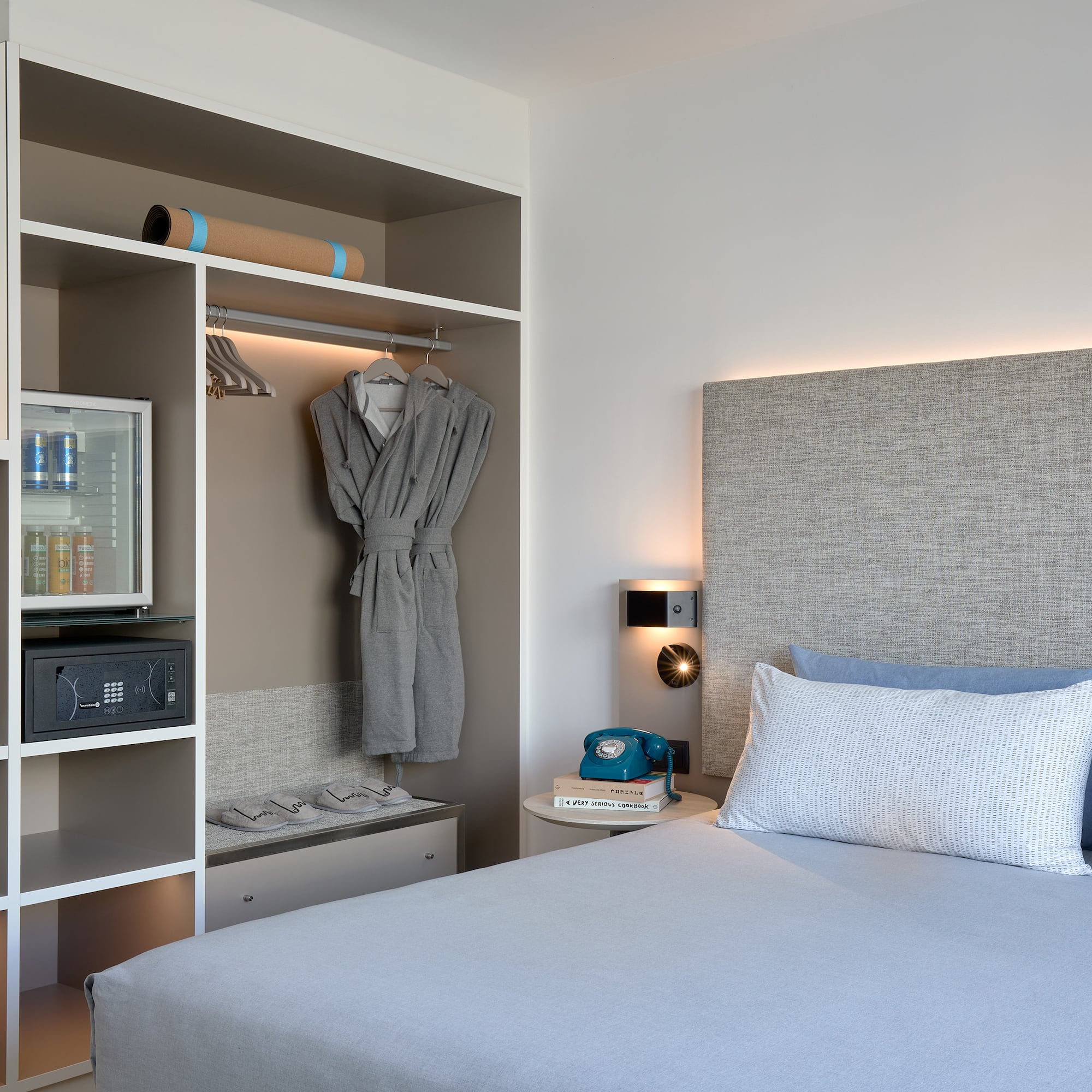 a bed with a white headboard and a shelf with a towel on it