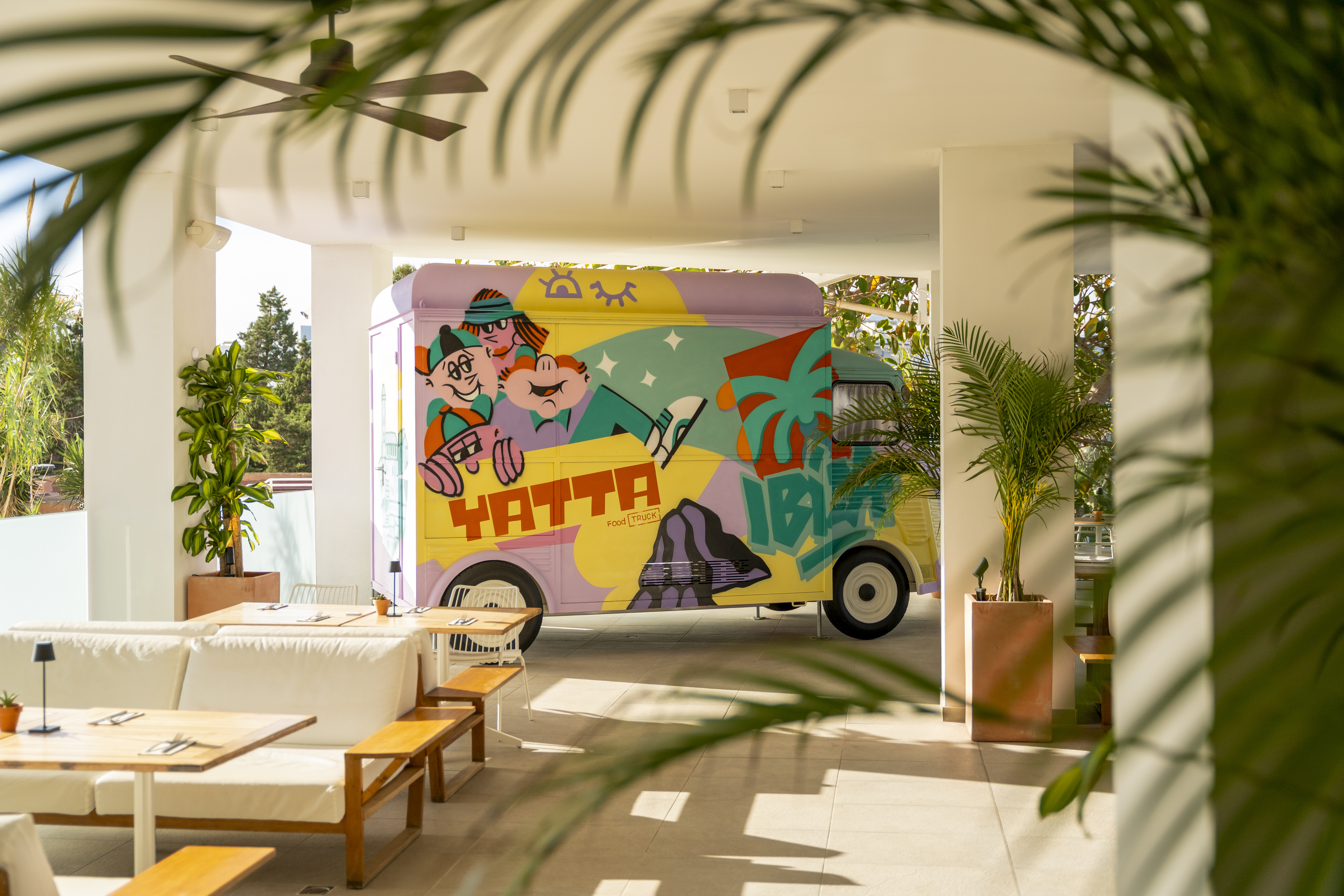 Yatta Food Truck with colorful graffiti art in an outdoor cafe setting.