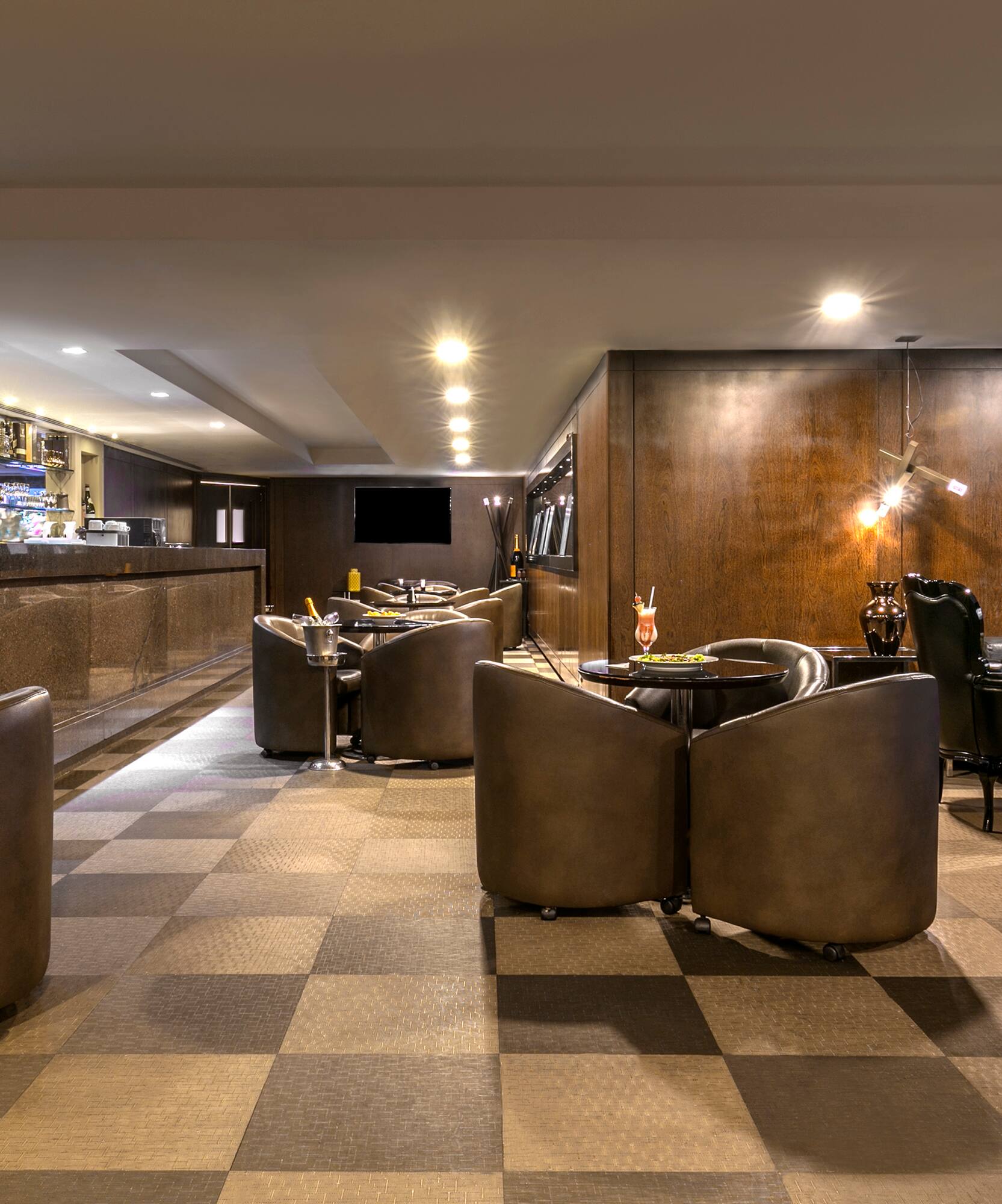 a room with a checkered floor and a bar with chairs and tables
