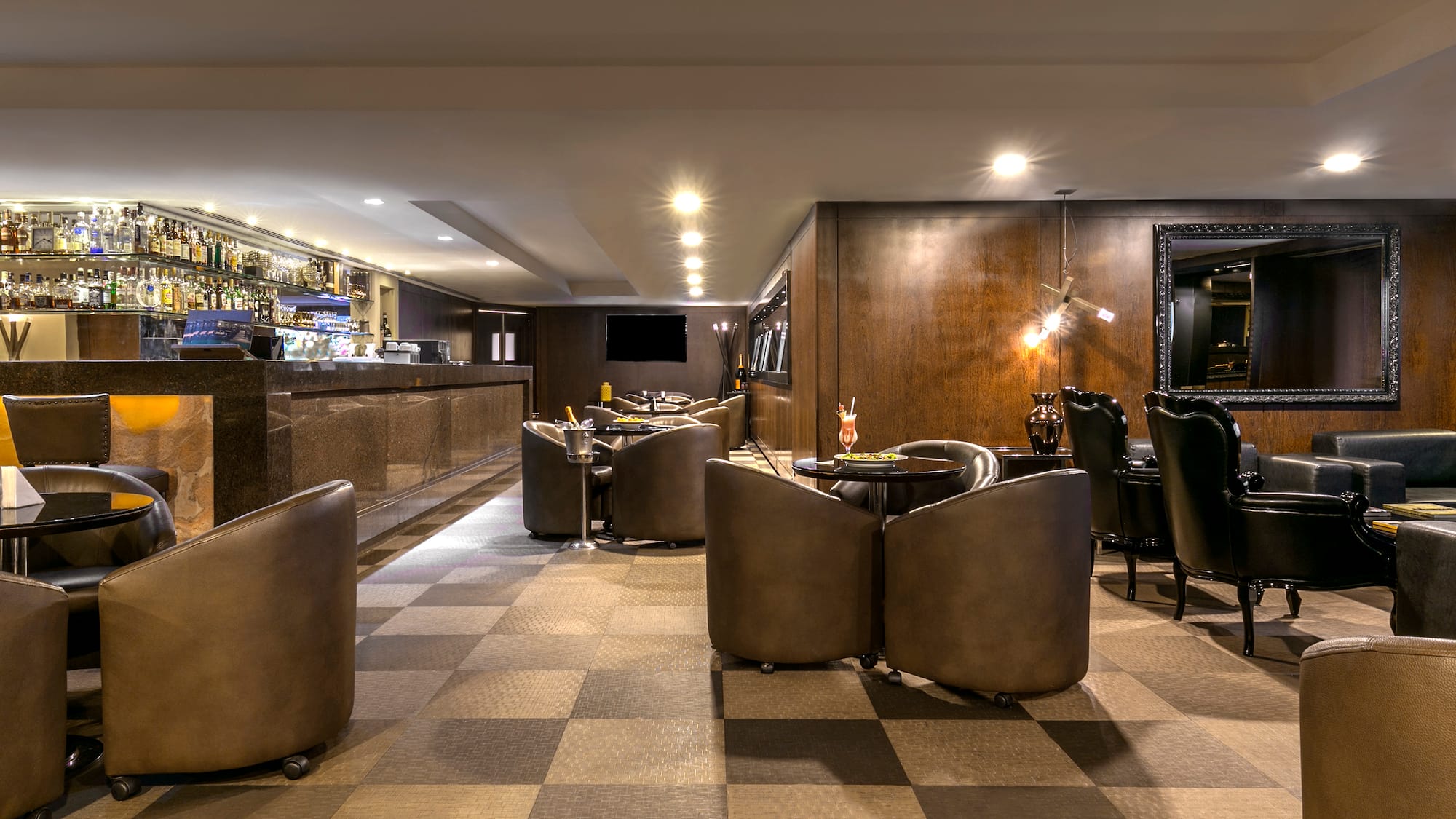 a room with a checkered floor and a bar with chairs and tables