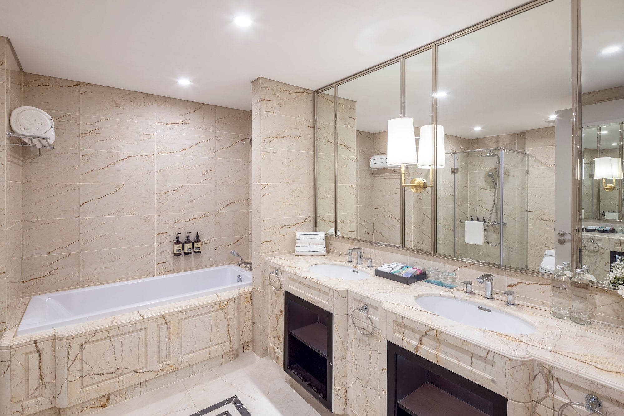 a bathroom with marble countertops and a tub
