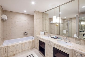 a bathroom with marble countertops and a tub