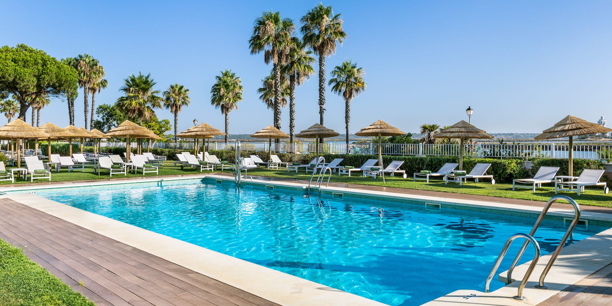 a pool with chairs and umbrellas