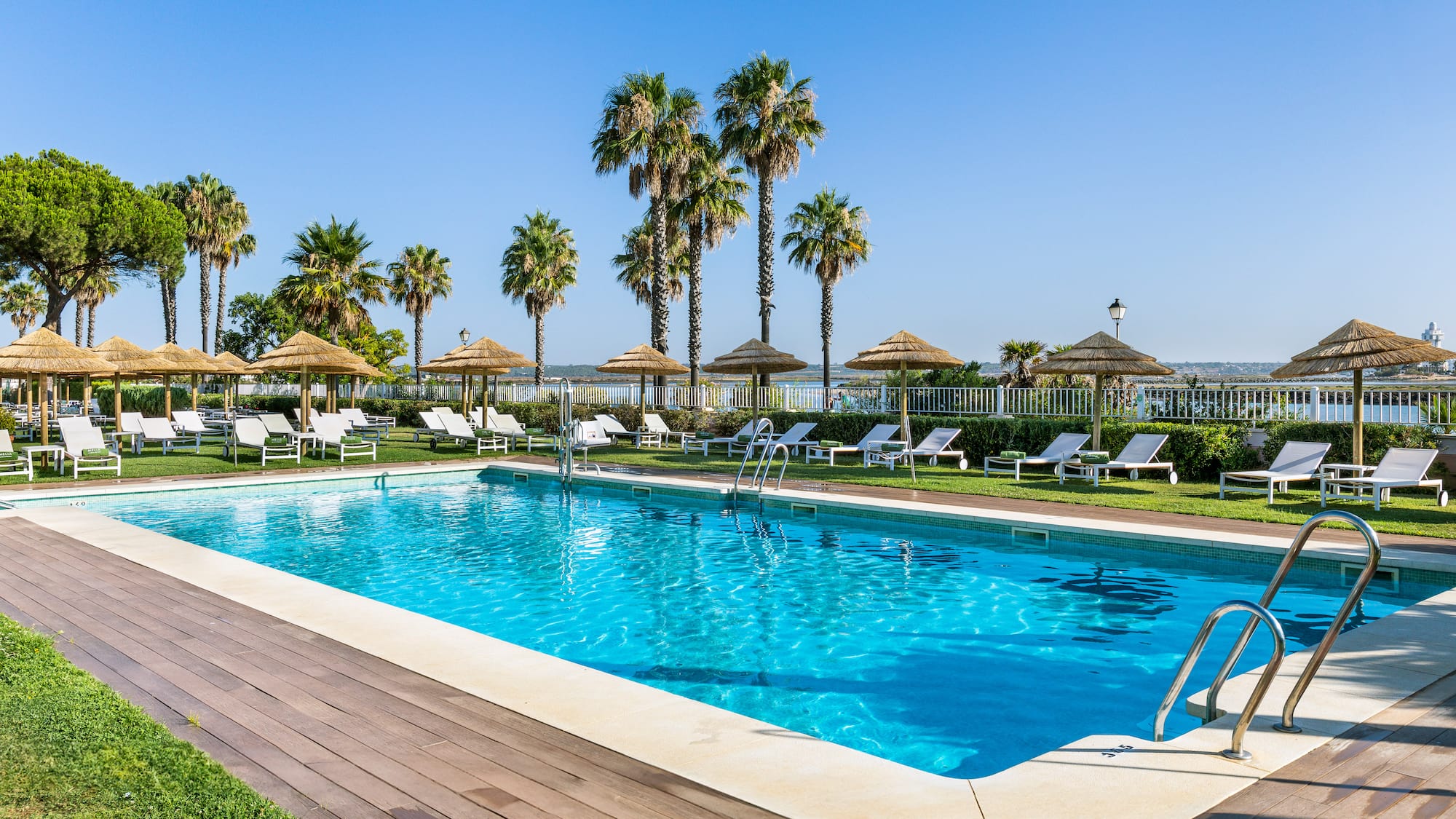 a pool with chairs and umbrellas