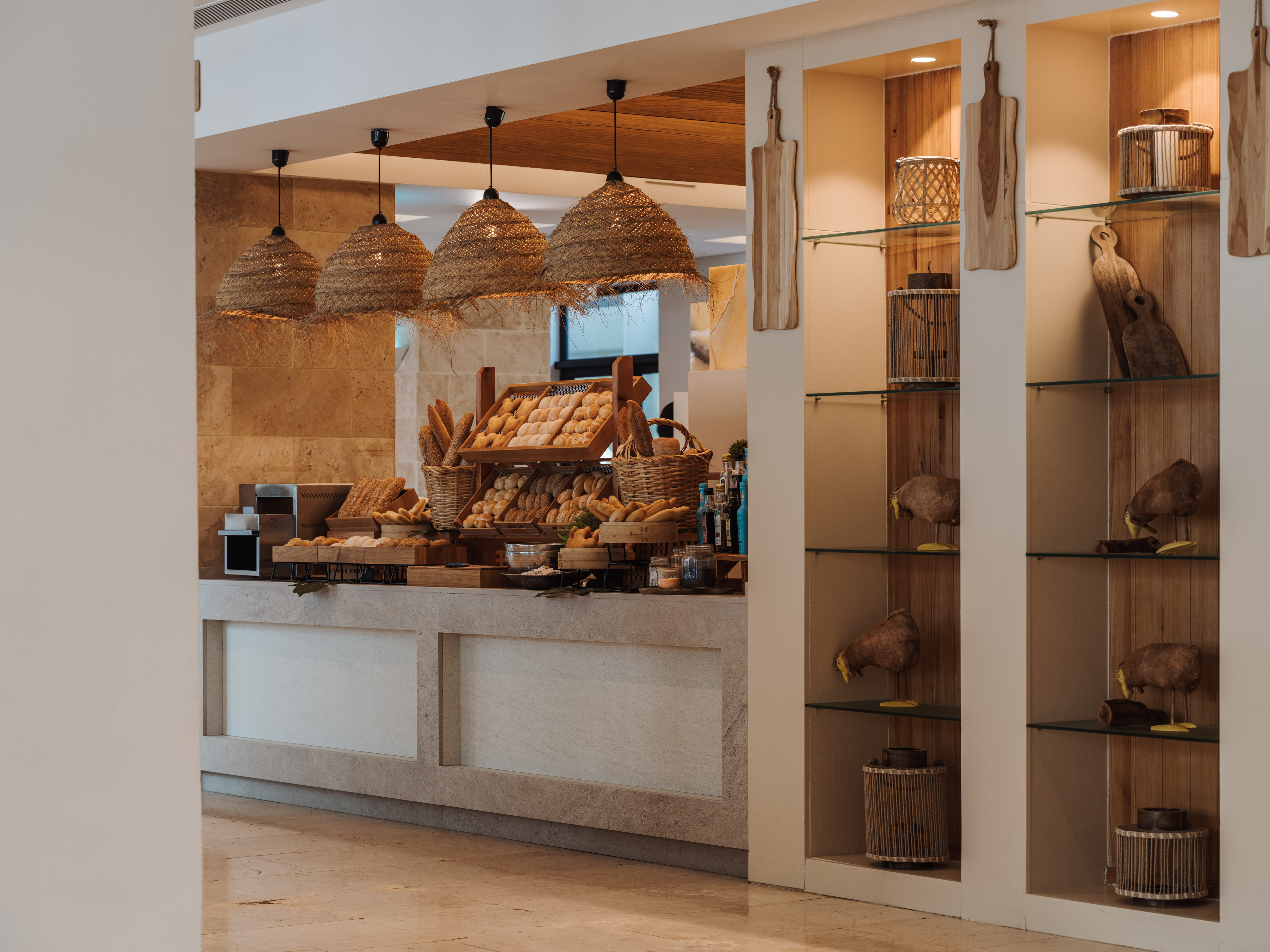 Hotel breakfast buffet with fresh bread, rattan lights, and rustic wooden decor.