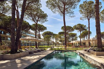a pool with umbrellas and chairs in a resort