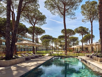 a pool with umbrellas and chairs in a resort