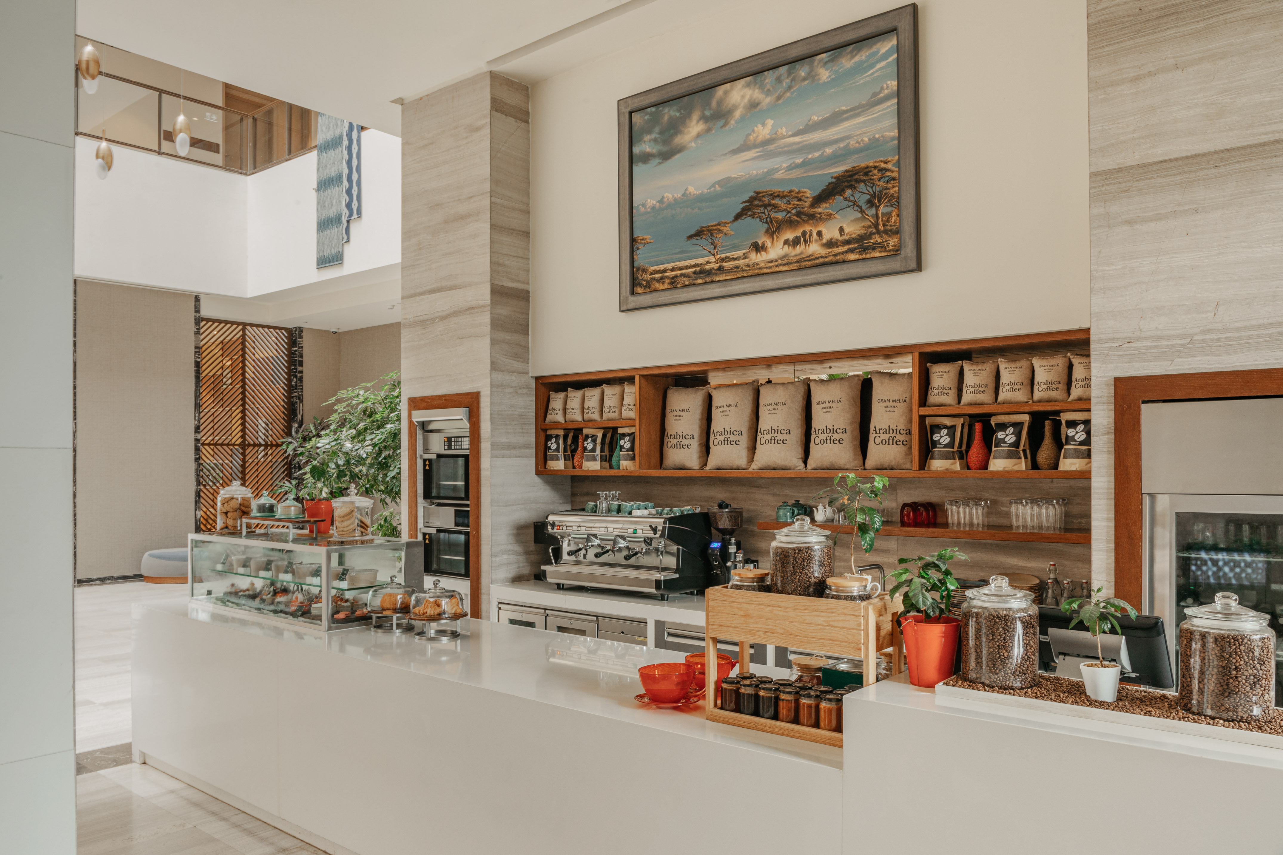 Modern hotel cafe: espresso machine, Arabica coffee, pastries on counter.