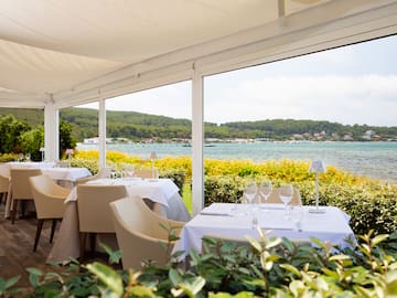 a table set up with chairs and glasses on it