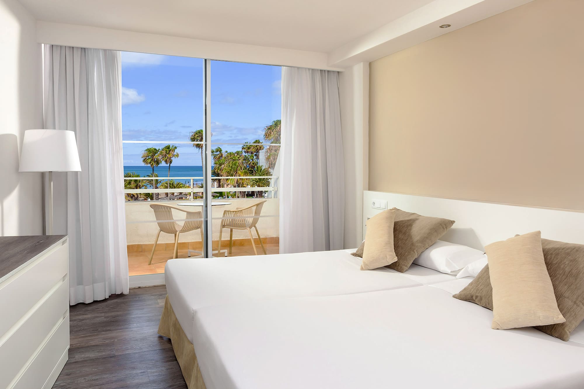 a hotel room with a view of the ocean and a balcony