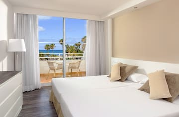 a hotel room with a view of the ocean and a balcony