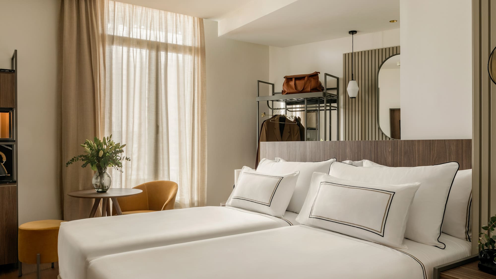 a room with white bedding and a mirror