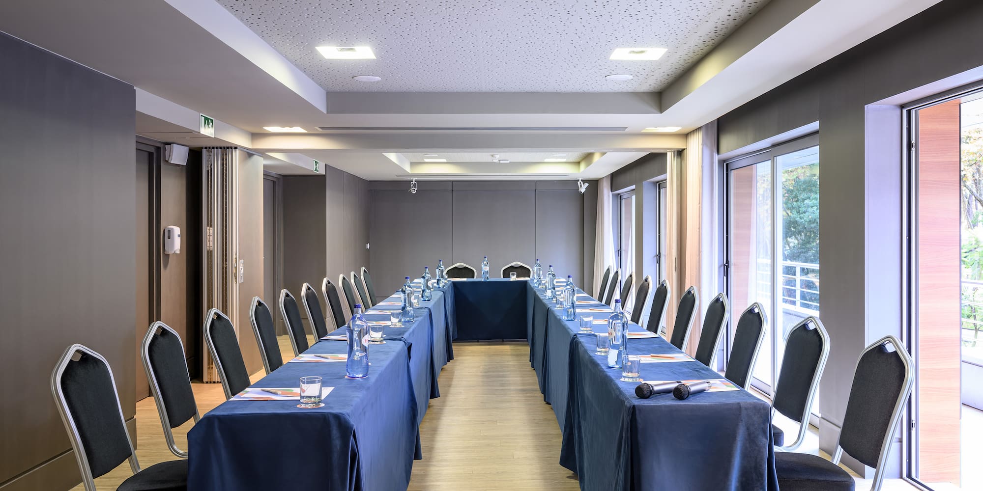 a long table with blue tablecloths and chairs in a room
