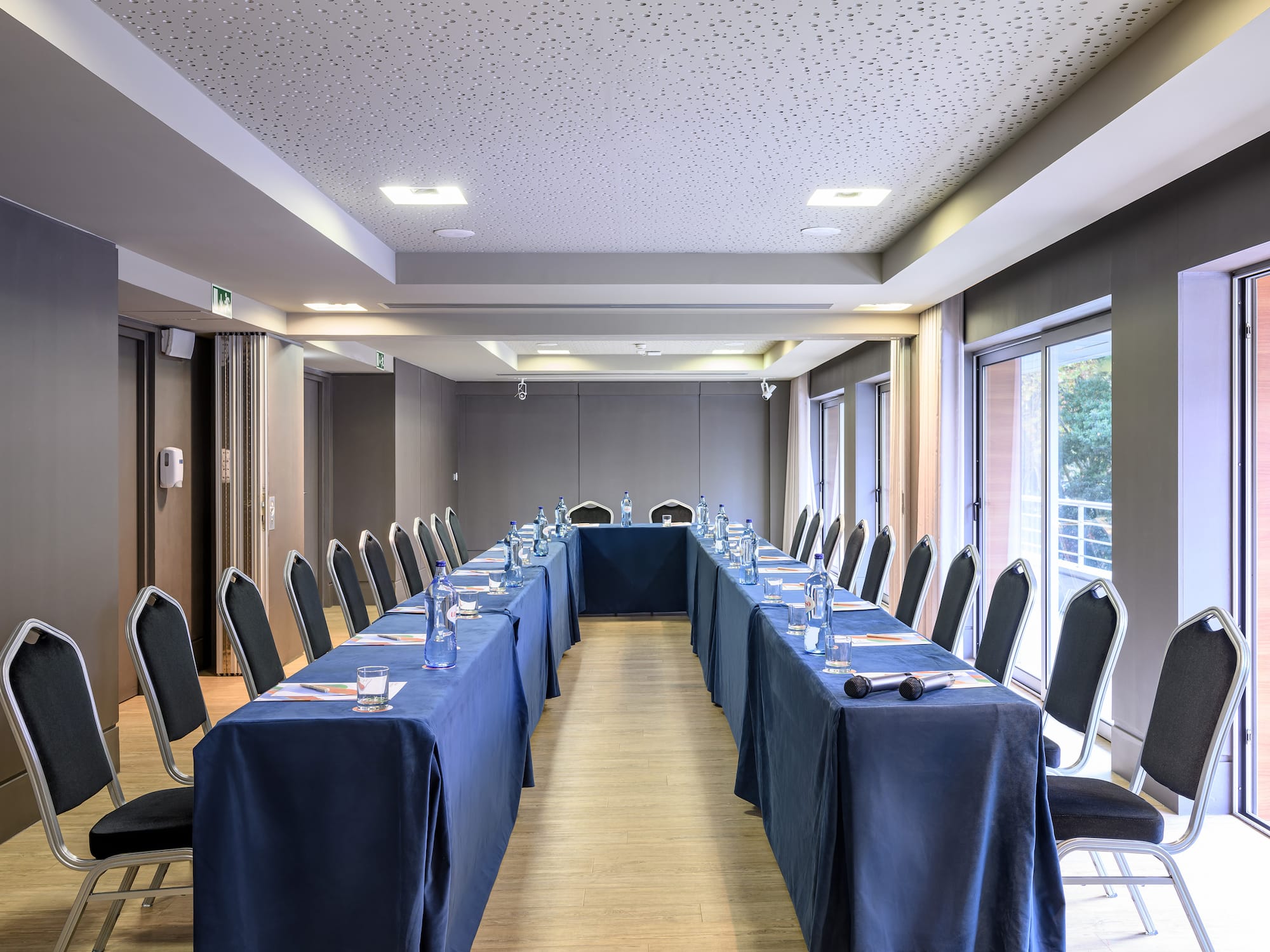 a long table with blue tablecloths and chairs in a room