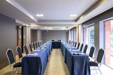 a long table with blue tablecloths and chairs in a room