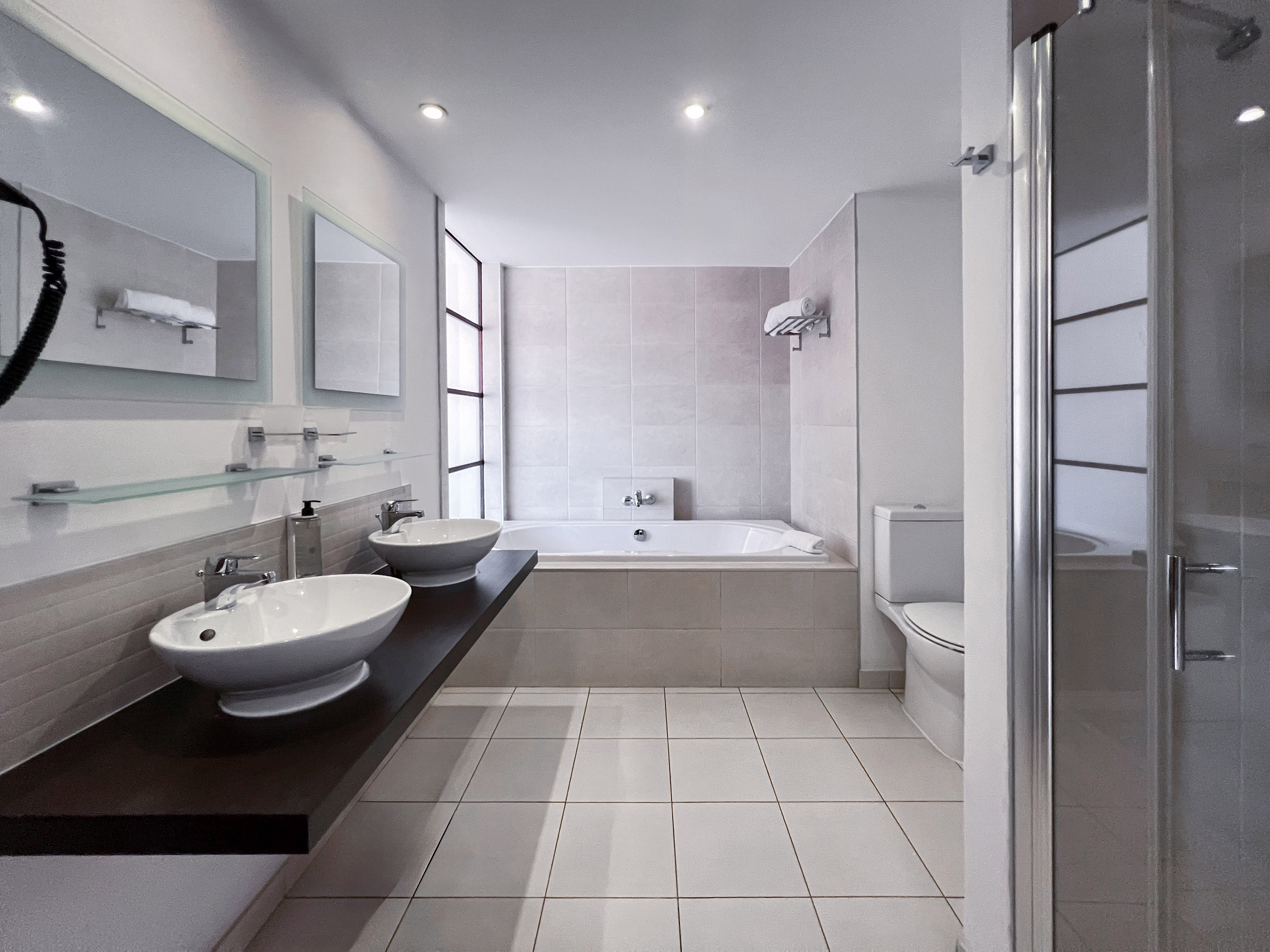 a bathroom with a tub and sinks