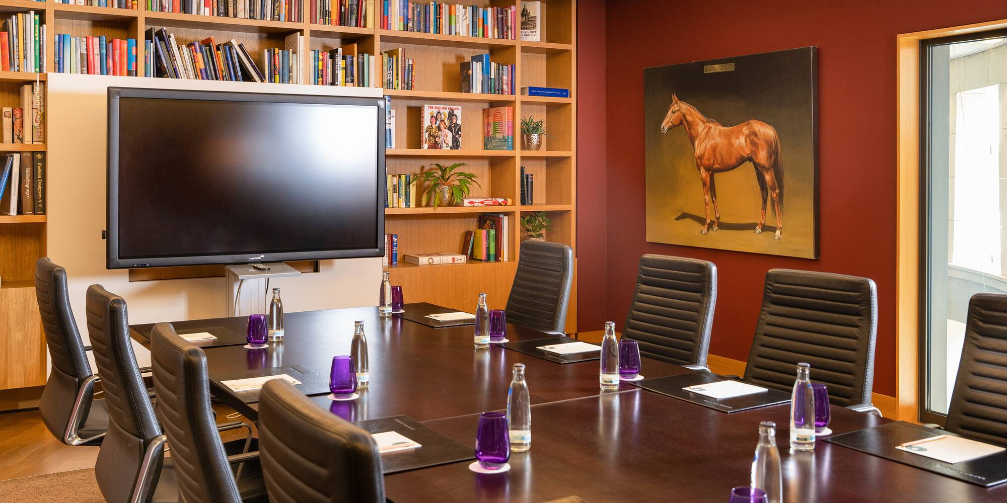 a room with a table and chairs and a tv
