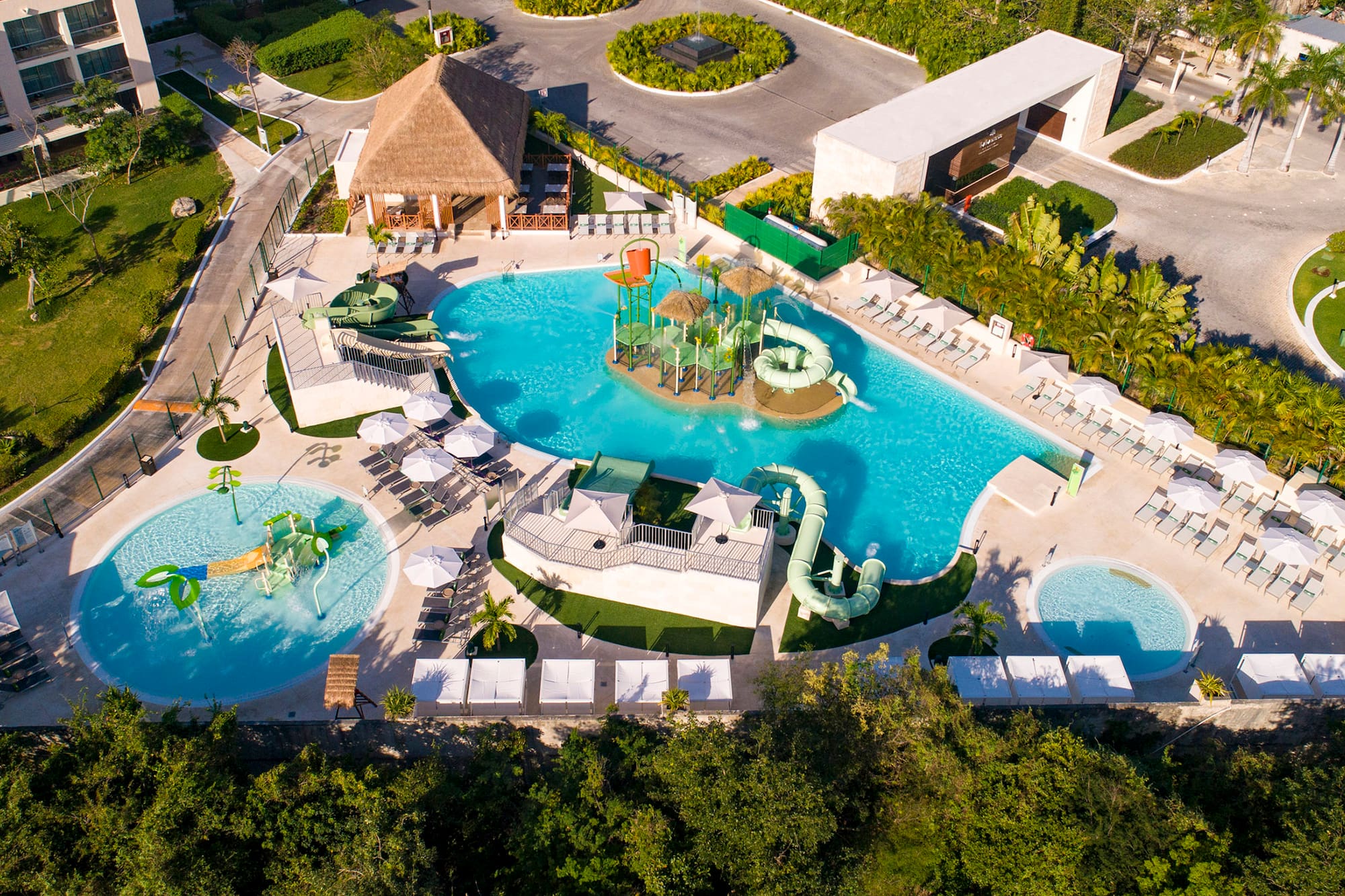 Luxury resort water park with multiple pools, slides, and hotel buildings.