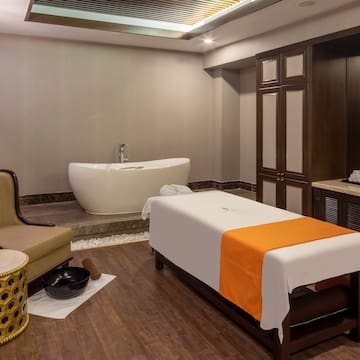 a room with a massage table and a tub