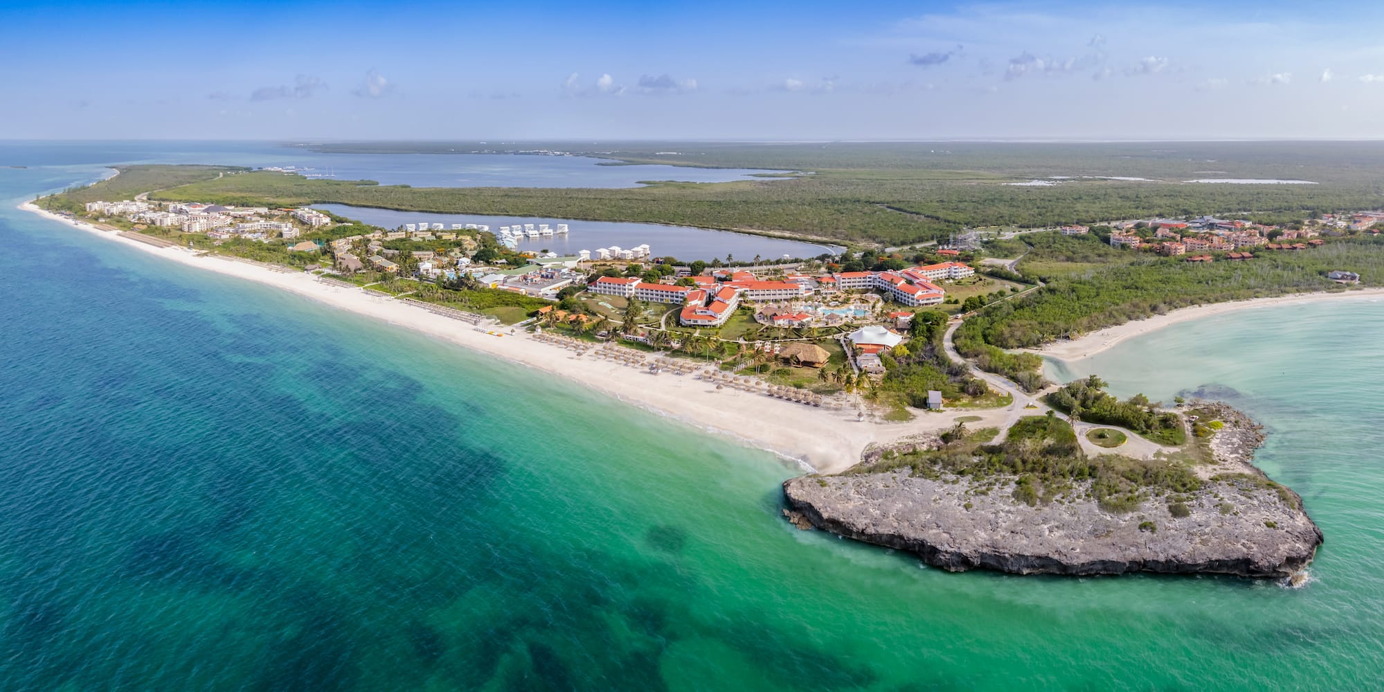 a beach with buildings and a body of water