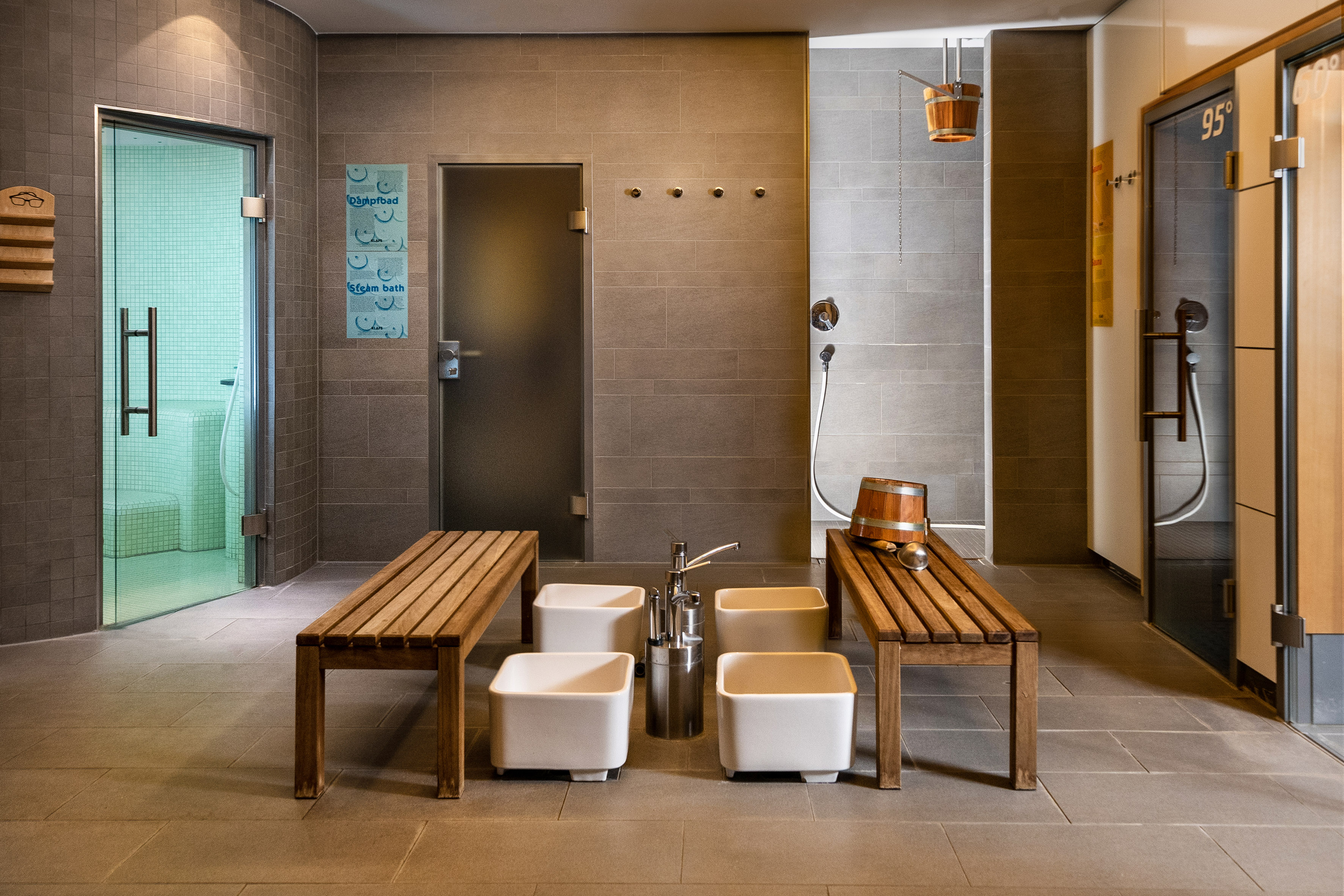 Spa wellness facility with steam bath, sauna, foot baths, and showers.