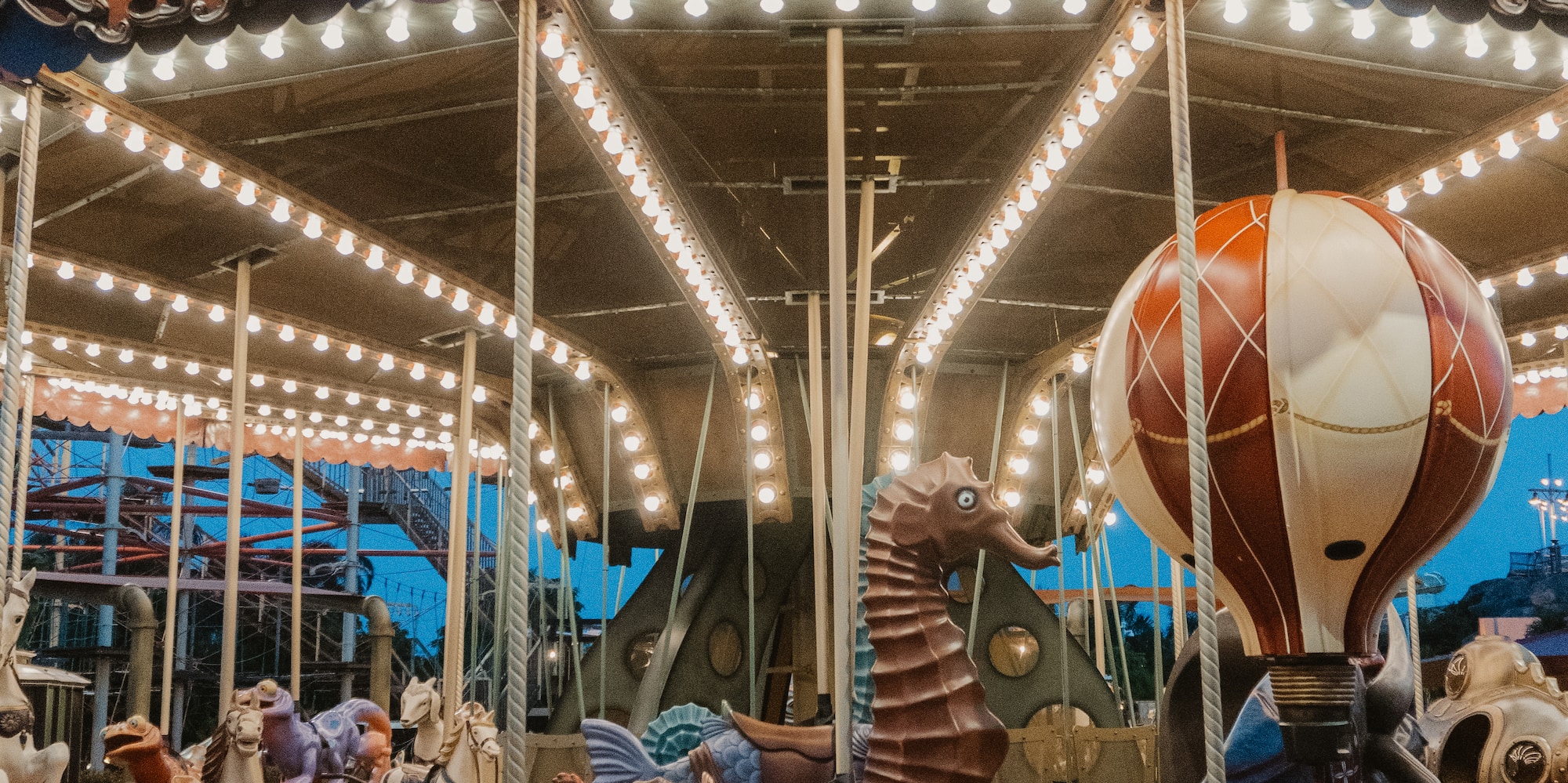a merry go round with lights and people riding on a bike