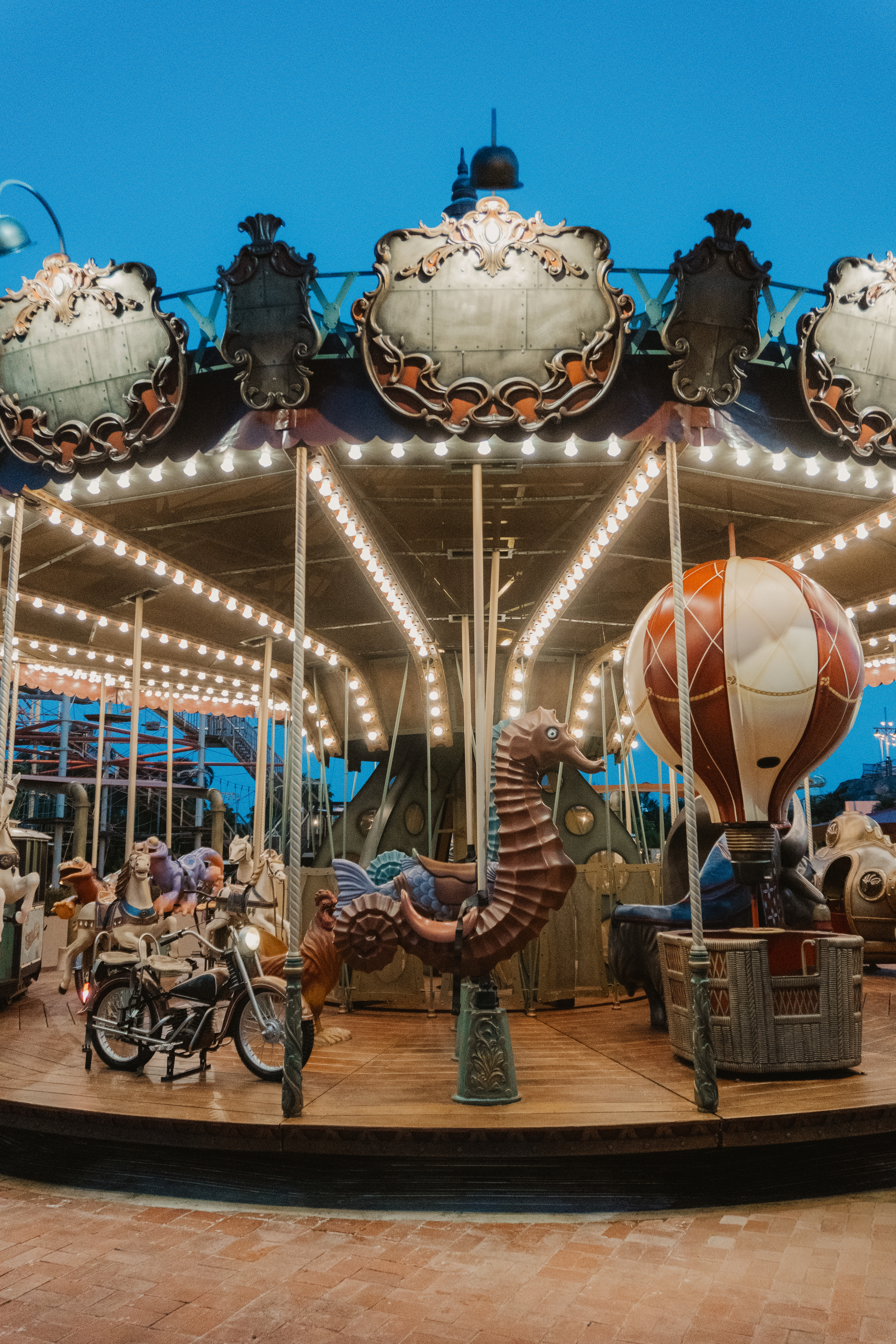 a merry go round with lights and people riding on a bike