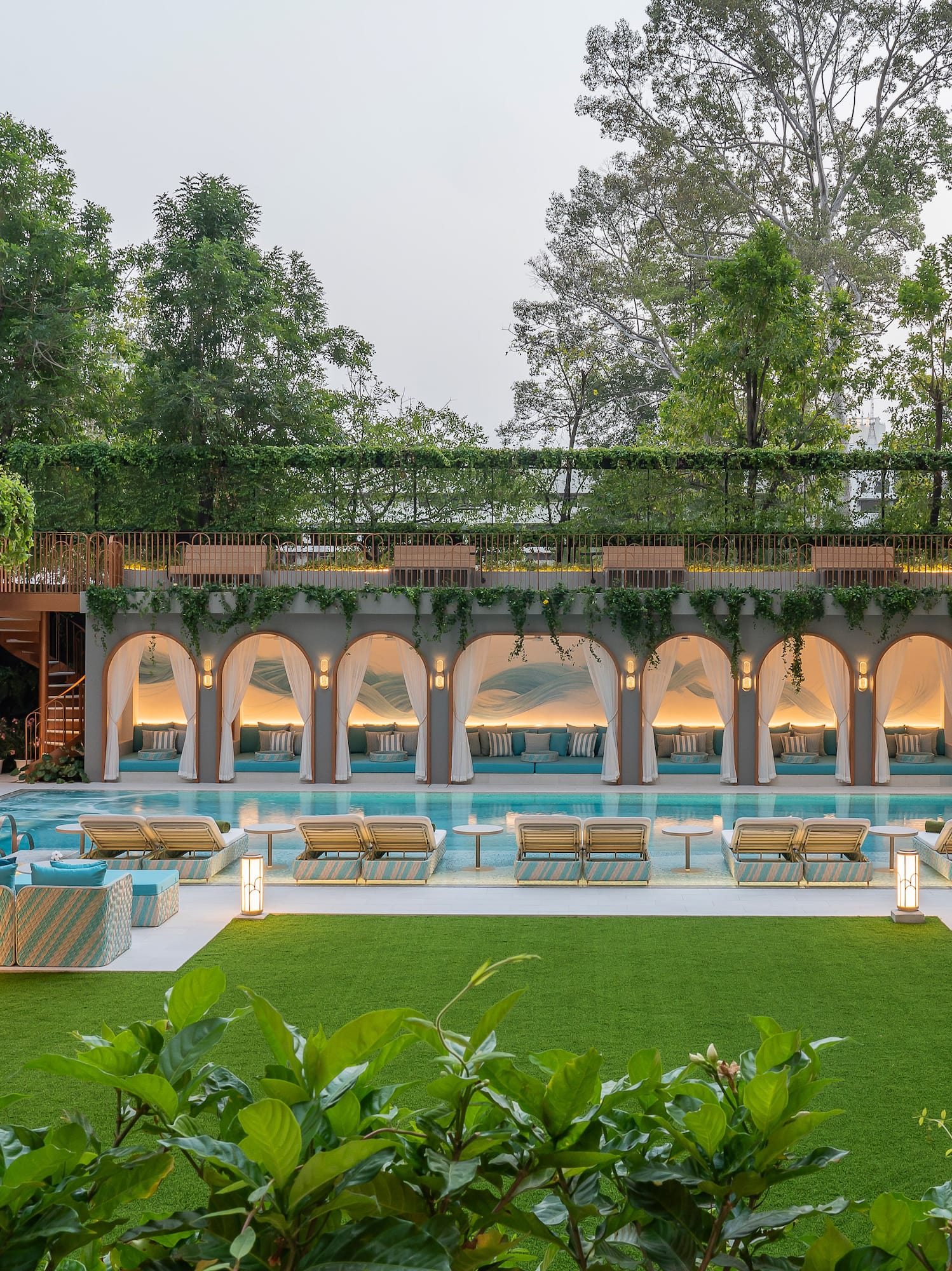 a pool with chairs and a green lawn