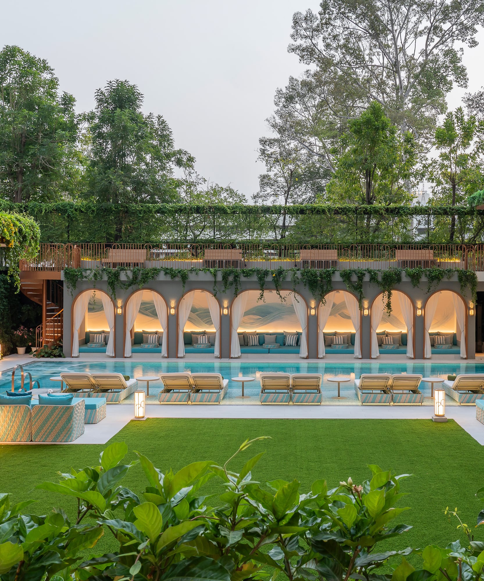 a pool with chairs and a green lawn