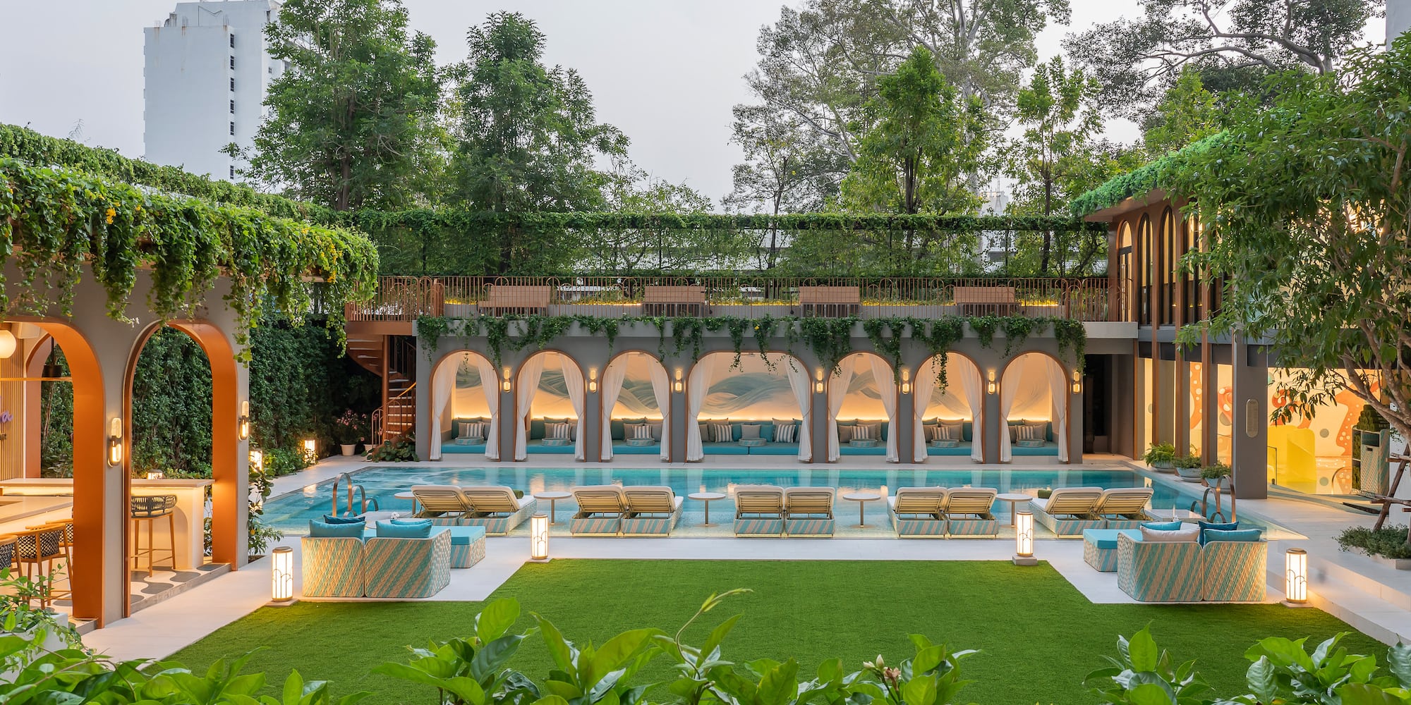 a pool with chairs and a green lawn