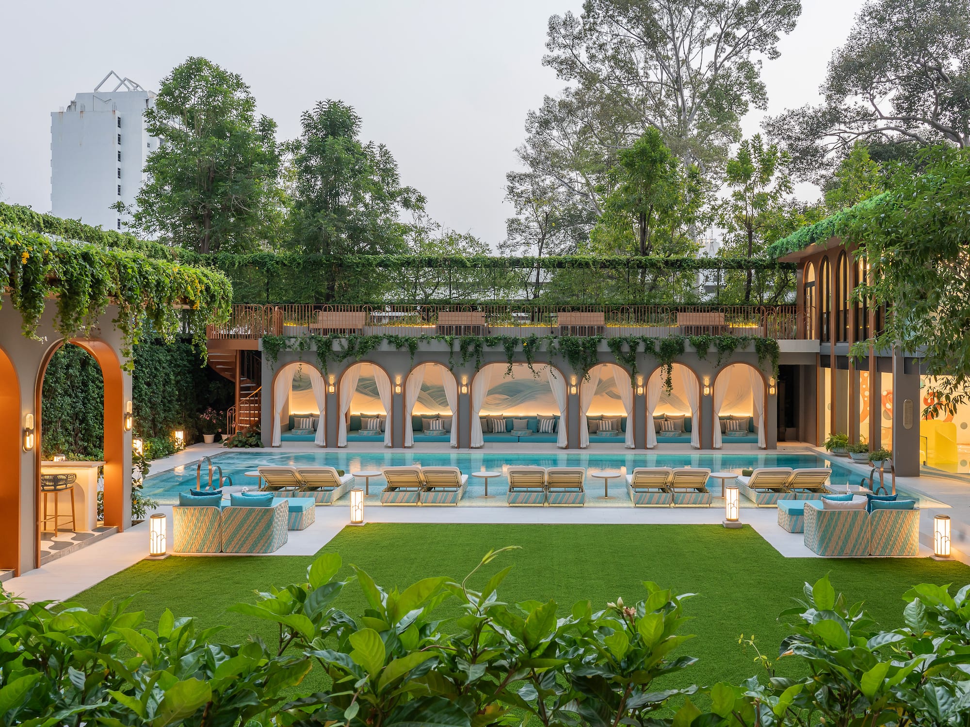 a pool with chairs and a green lawn