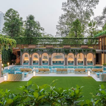 a pool with chairs and a green lawn