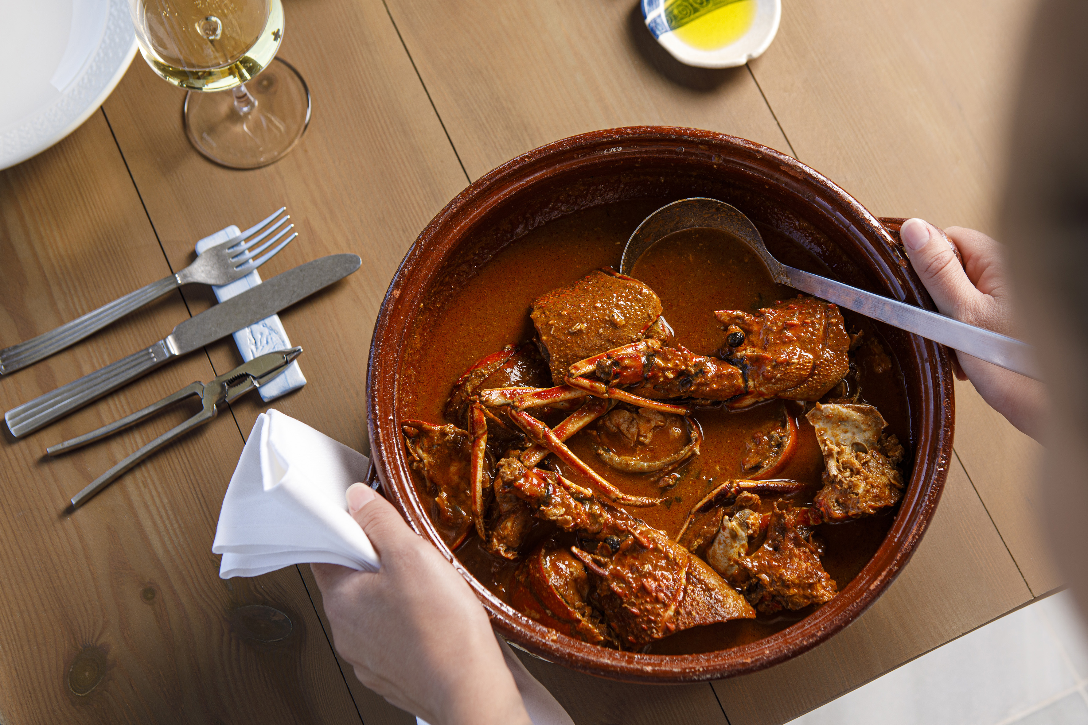 a bowl of food with a napkin and a glass of wine