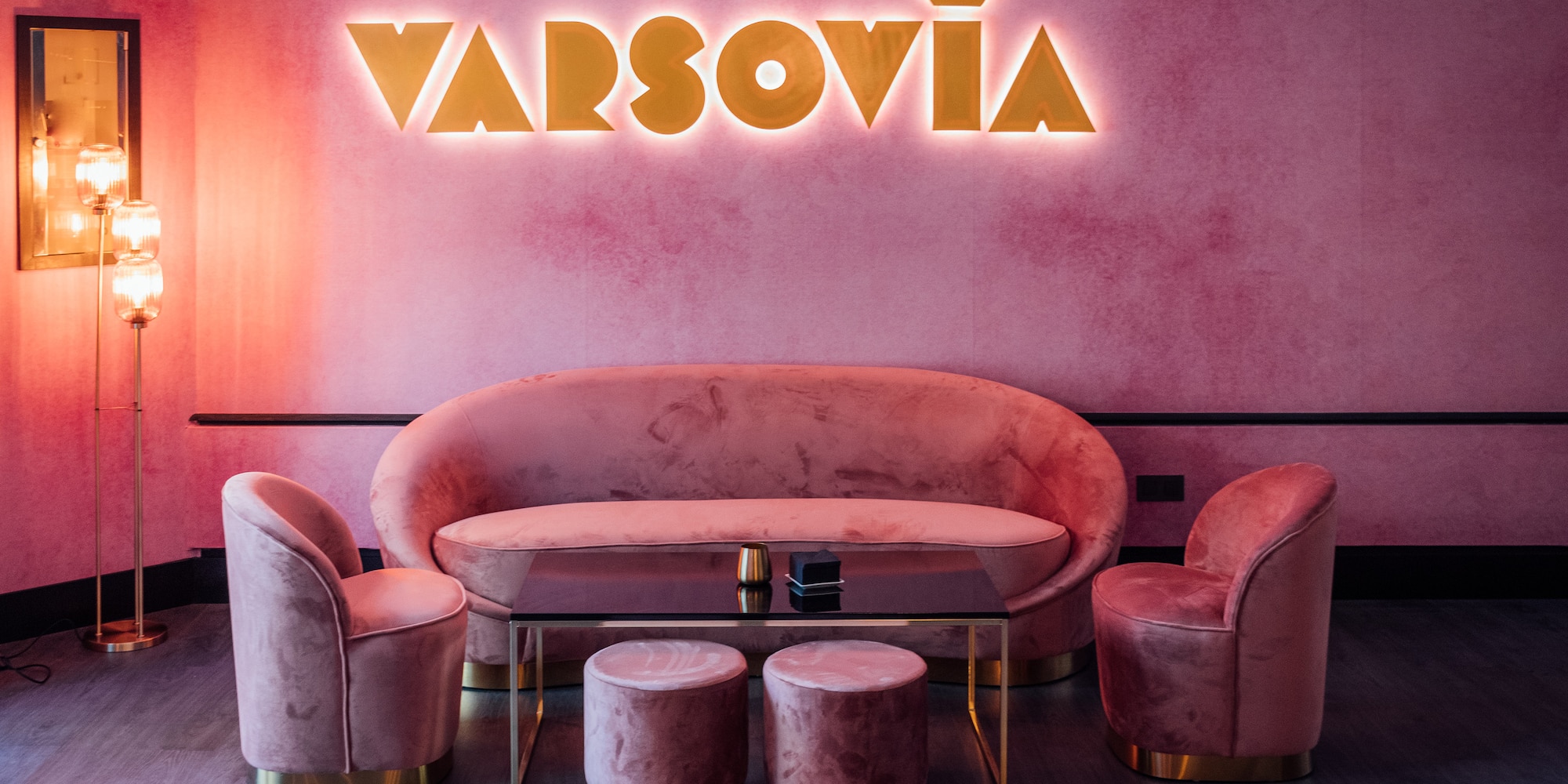 a pink couch and chairs in a room