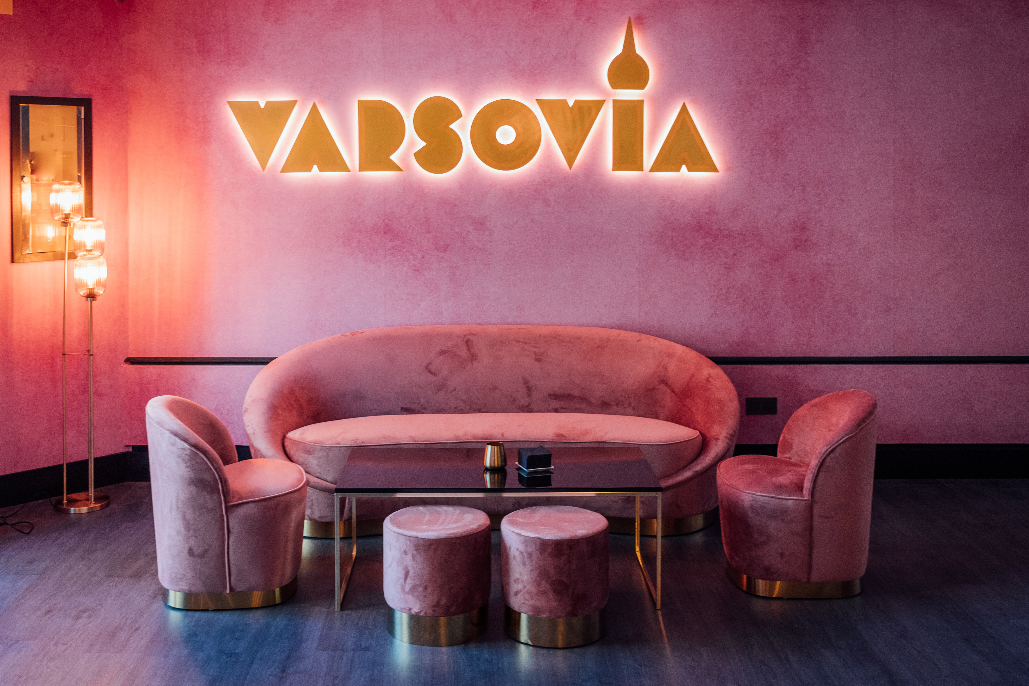 a pink couch and chairs in a room