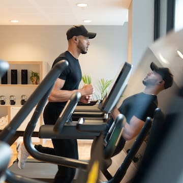 a man in a cap running on a treadmill