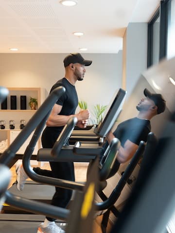 a man in a cap running on a treadmill