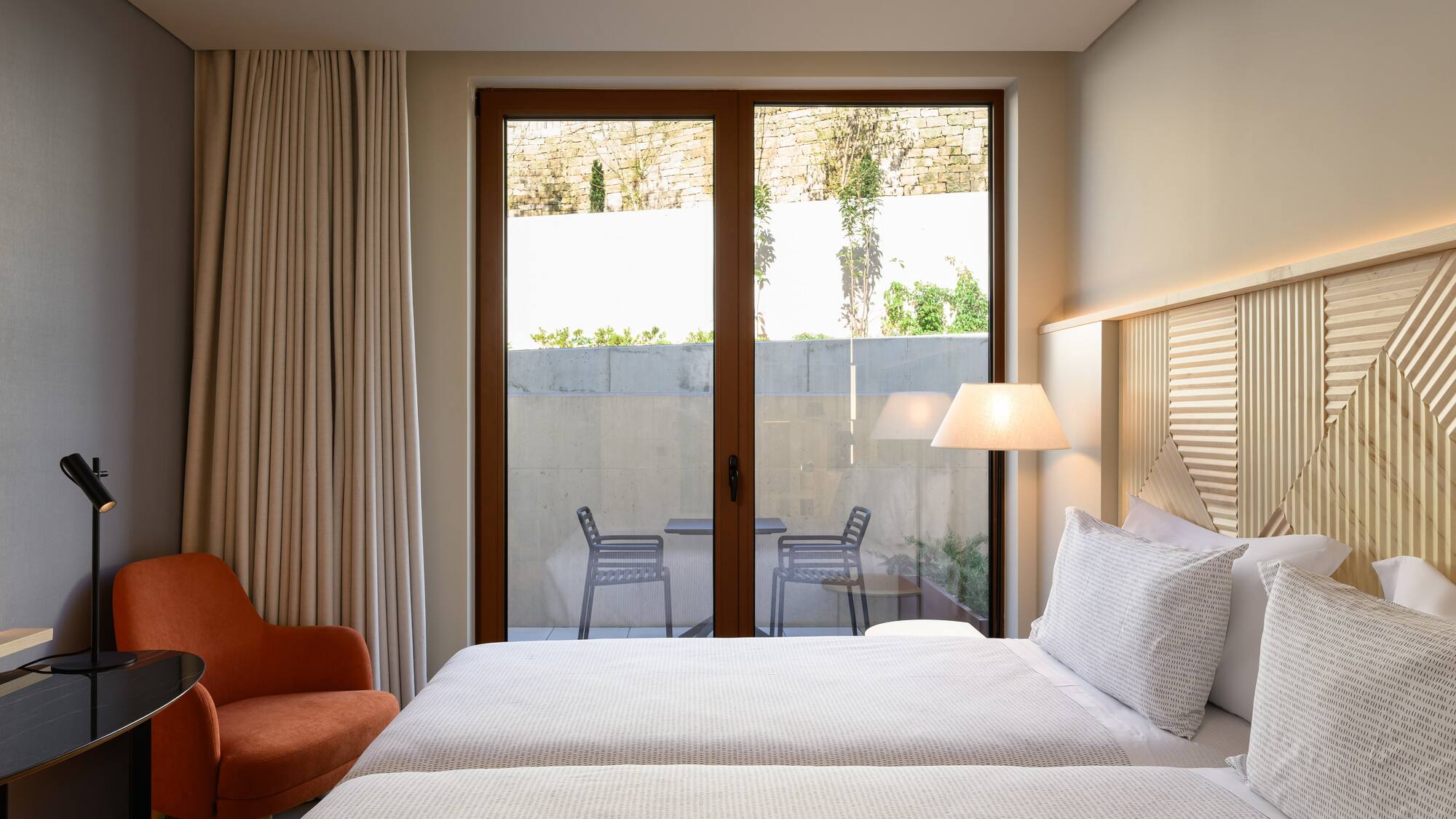 two beds in a room with a glass door