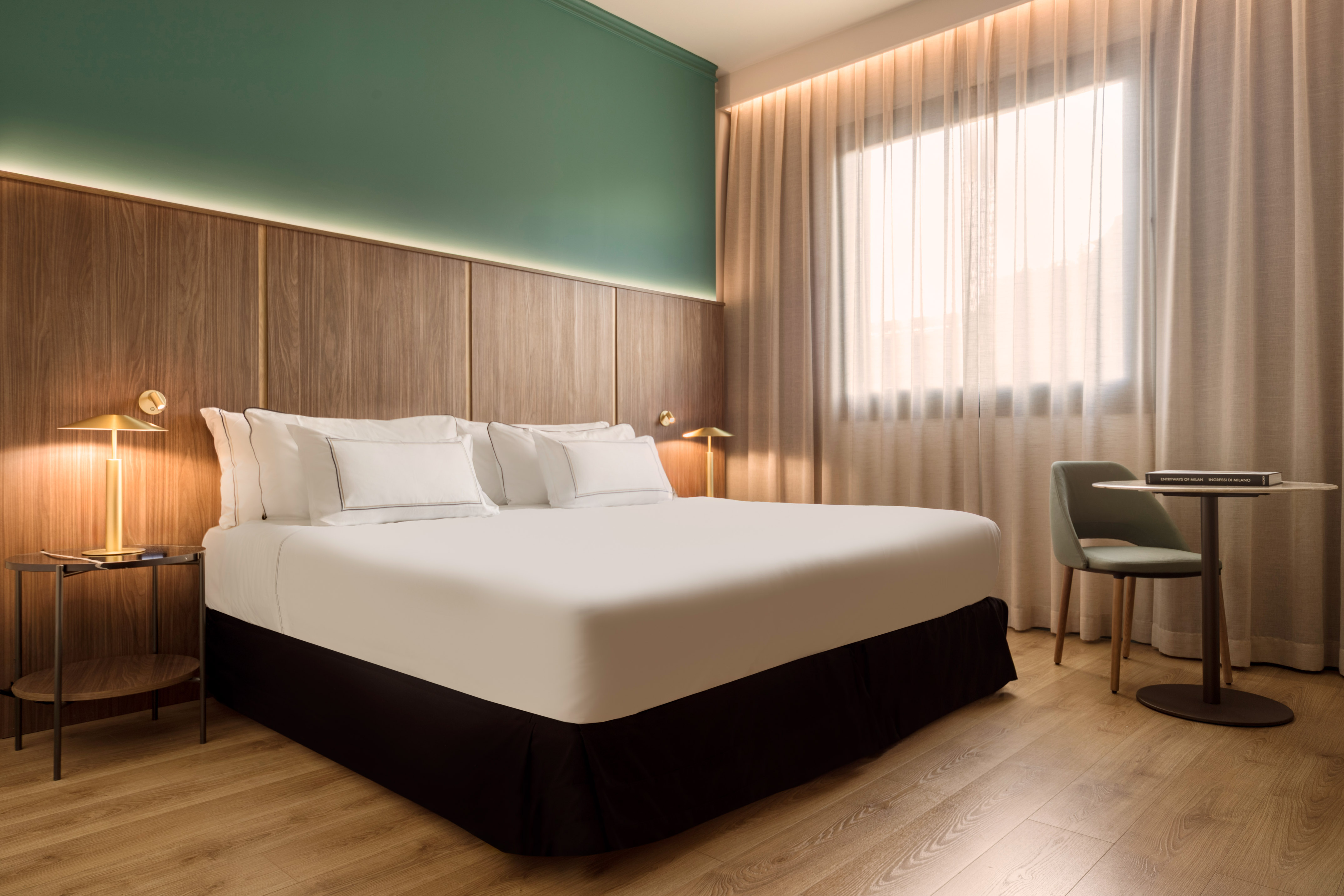 a bed with white sheets and a chair in a room