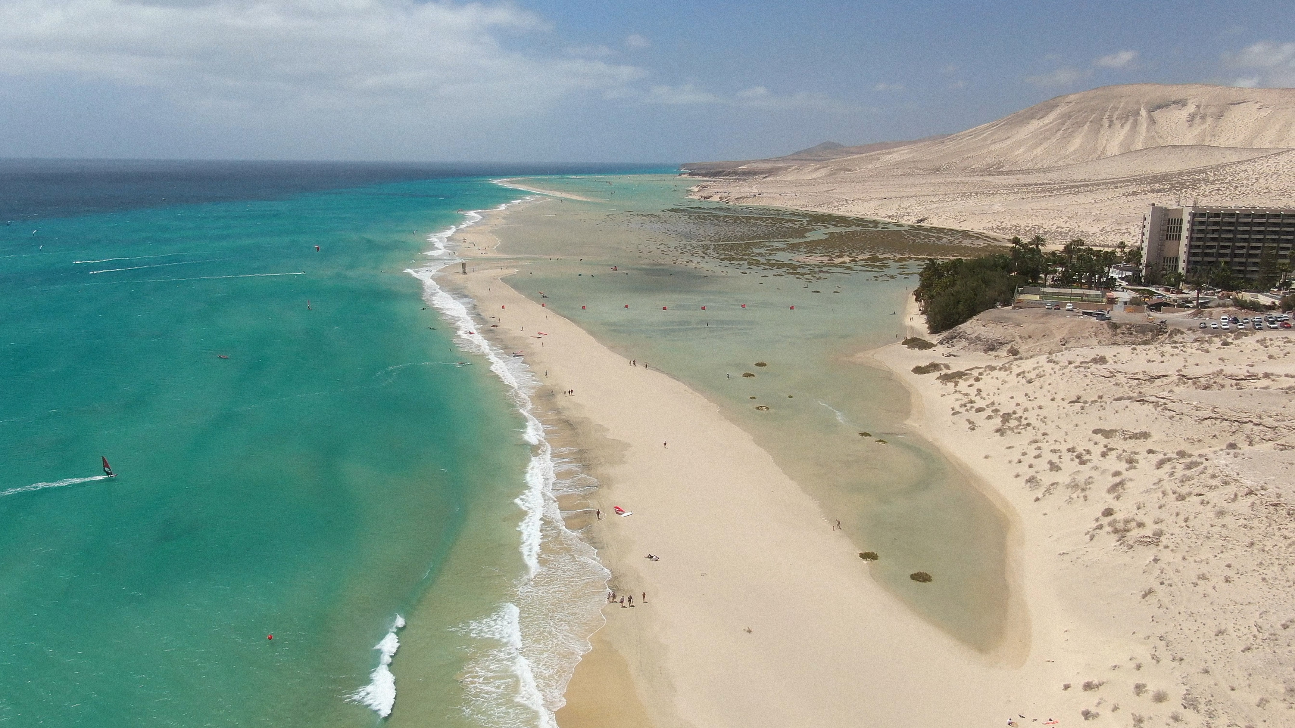 Playa Jandía, Fuerteventura: océano turquesa, windsurf, laguna, dunas y hotel.