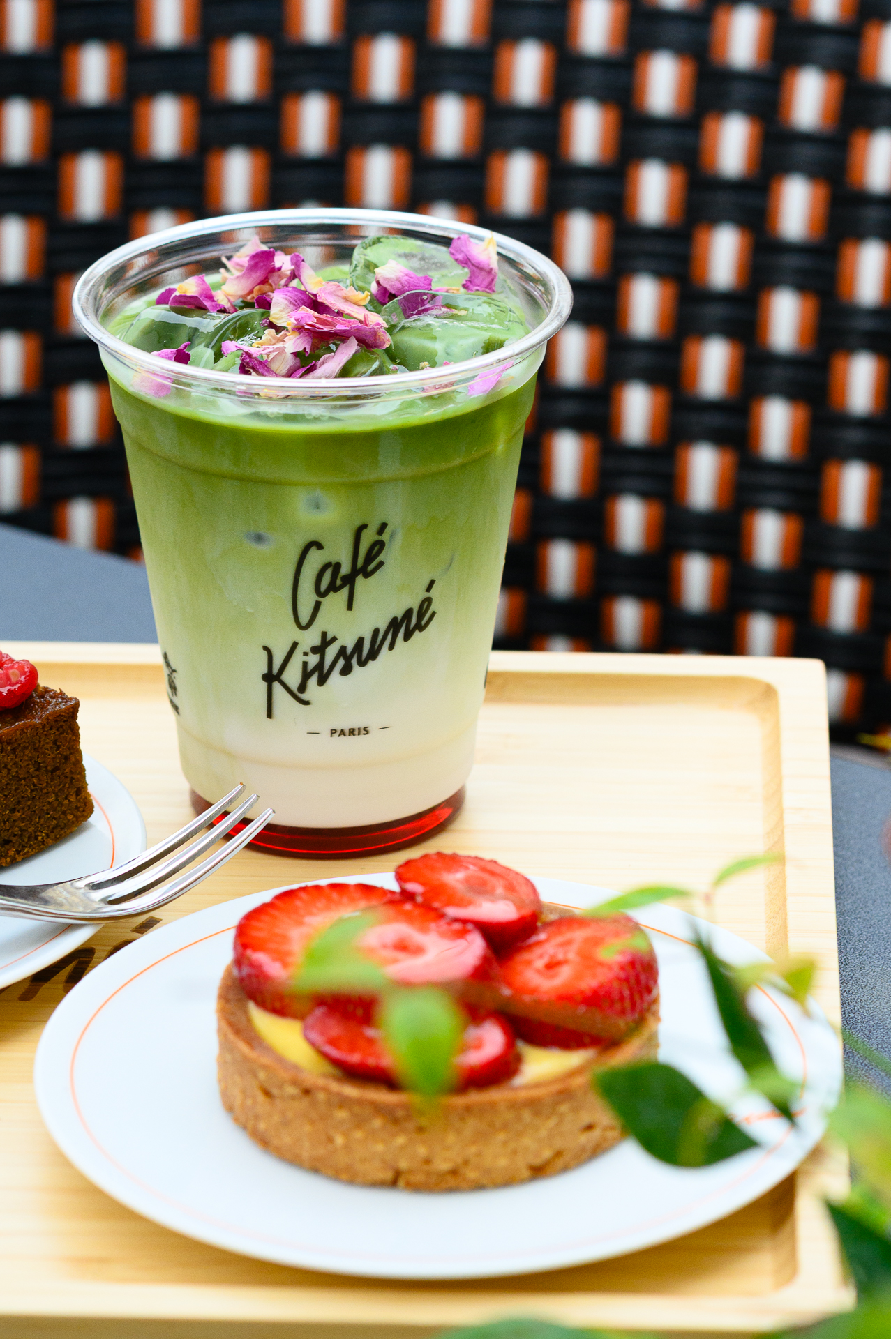 Cafe Kitsune matcha latte with rose petals, strawberry tart, and cake.