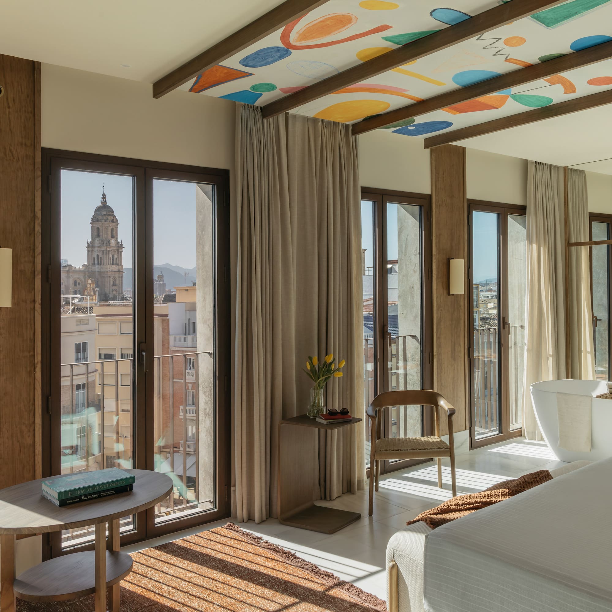 a room with a bed and a table and chairs