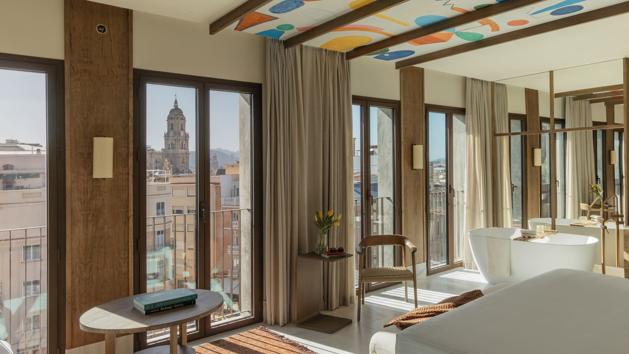 a room with a bed and a table and chairs