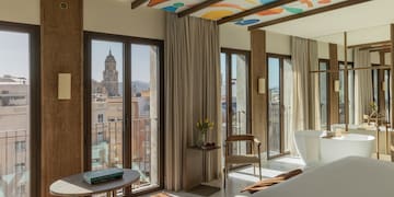 a room with a bed and a table and chairs