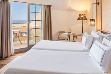 a room with two beds and a glass door