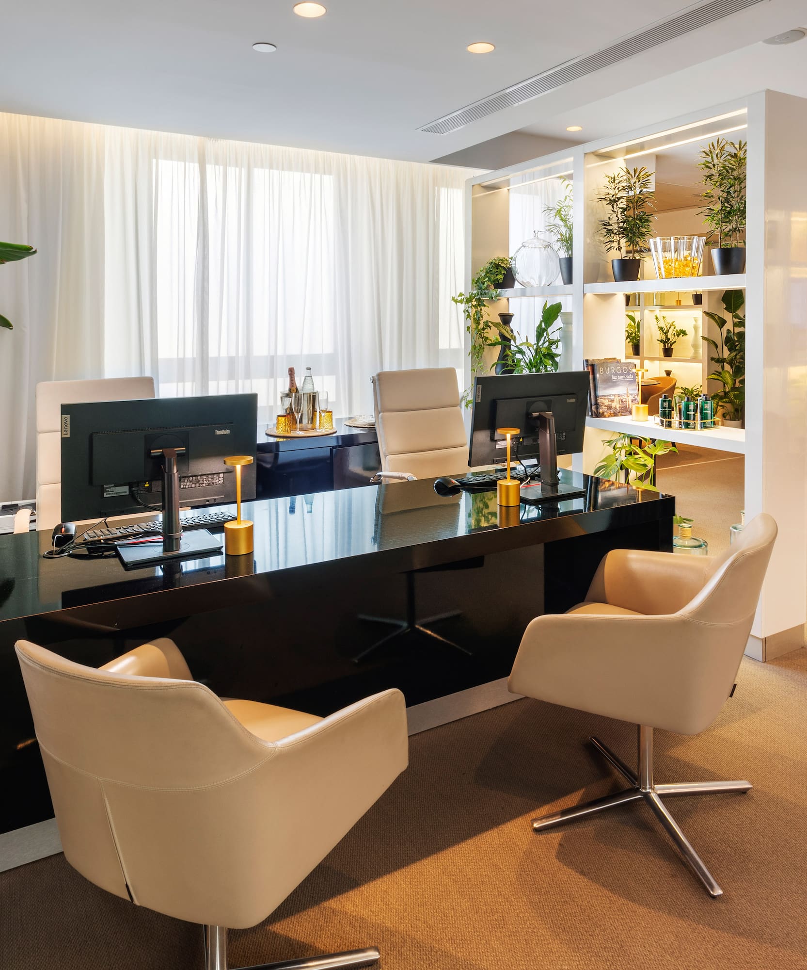 a room with a black desk and chairs