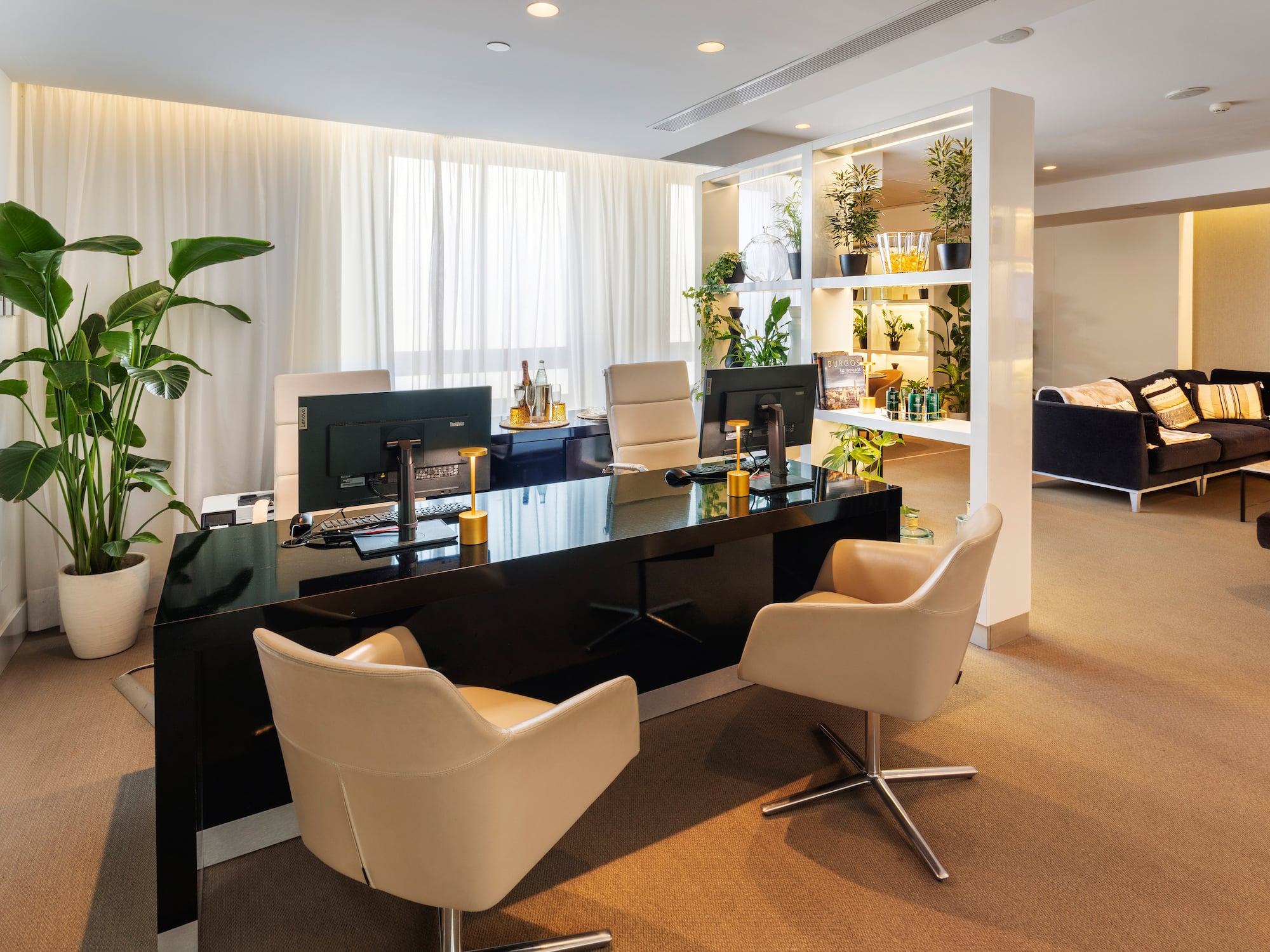 a room with a black desk and chairs