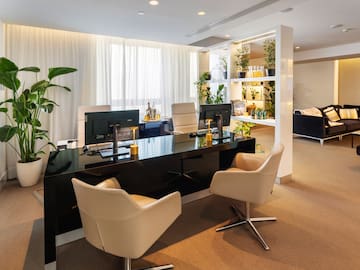 a room with a black desk and chairs